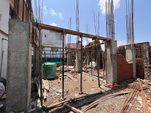 Structural construction phase of an ST Builders residential project in Sankhamul, Kathmandu, showing concrete columns and steel reinforcement.