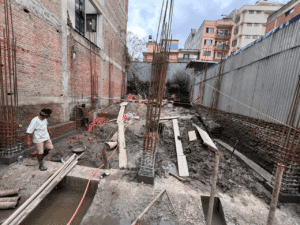 Foundation excavation and RCC column reinforcement work during a turnkey construction project by ST Builders in Bhotebahal, Kathmandu.