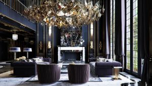 Luxury living room interior design in Nepal featuring a grand crystal chandelier, marble wall accents, and premium furniture.