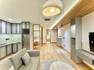 Modern apartment interior in Nepal featuring a modular kitchen, warm wood ceiling, and contemporary furniture.