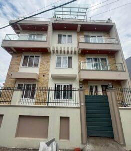 Finished residential building in Hattiban, Lalitpur by ST Builders showcasing the successful post-construction handoff, complete with modern exterior design and boundary wall.