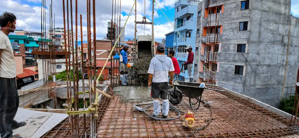 Construction workers pouring reinforced concrete roof slab at ST Builders' residential project in Sankhamul, Kathmandu